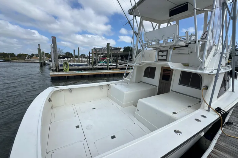 Slide: The Image of 1985 Blackfin 32 Flybridge boat docked at marina, featuring spacious deck and flybridge. - 21
