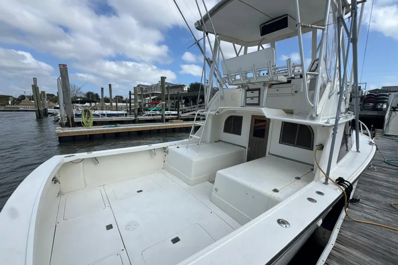 Slide: The Image of 1985 Blackfin 32 Flybridge boat docked at marina under cloudy sky. - 22