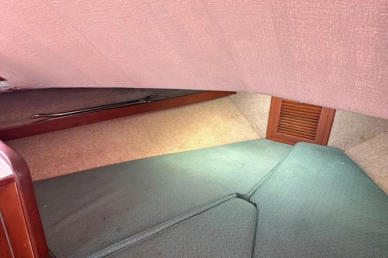 Slide: The Image of 1985 Blackfin 32 Flybridge cabin interior with cushioned seating and wooden accents. - 34