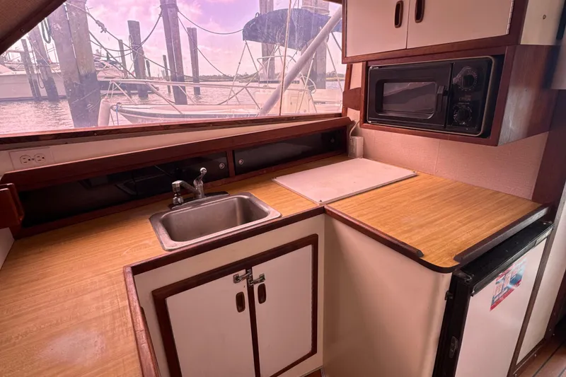 Slide: The Image of 1985 Blackfin 32 Flybridge kitchen with sink, microwave, and wooden countertops. - 35