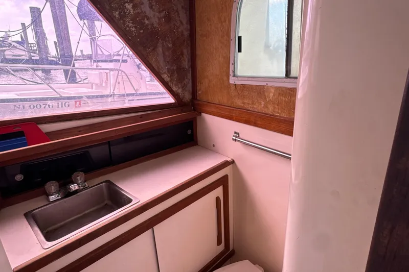 Slide: The Image of 1985 Blackfin 32 Flybridge interior with sink, window, and wooden accents. - 38