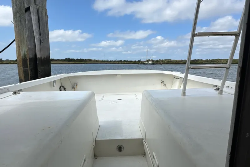 Slide: The Image of 1985 Blackfin 32 Flybridge boat docked, view of deck and water under blue sky. - 40