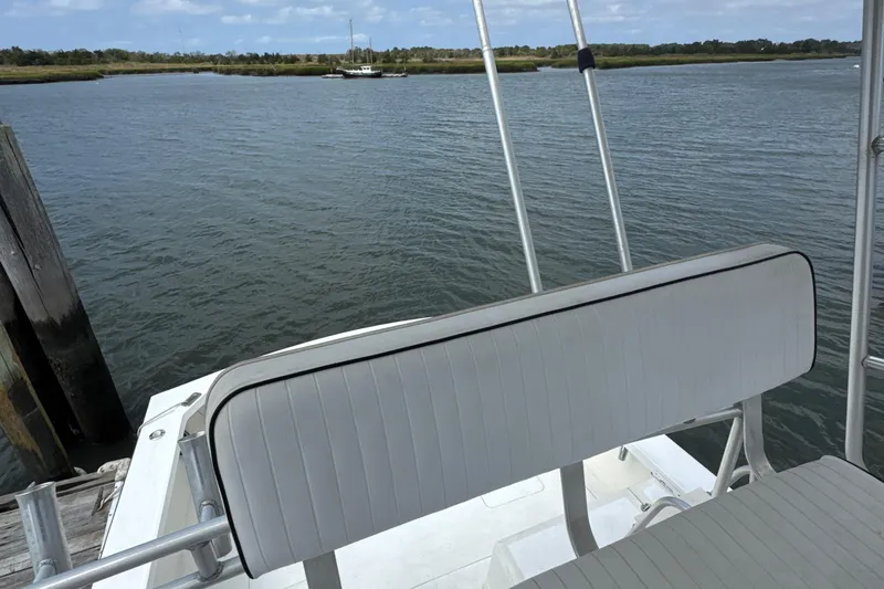 Slide: The Image of 1985 Blackfin 32 Flybridge boat with seating, docked by calm waters. - 43