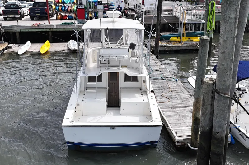 Slide: The Image of 1985 Blackfin 32 Flybridge boat docked at marina with kayaks and equipment. - 5