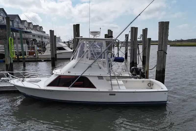 Slide: The Image of 1985 Blackfin 32 Flybridge boat docked at marina, featuring classic design and flybridge. - 8