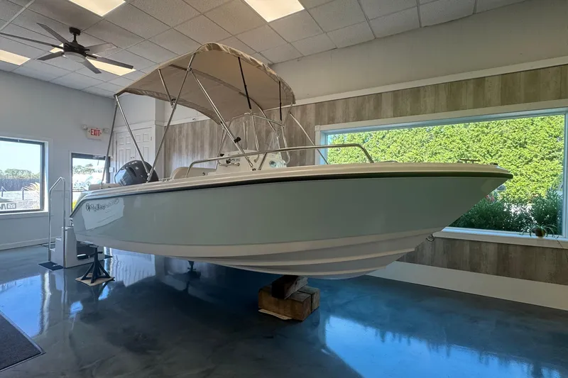 The Image of 2025 Edgewater 170CC boat displayed indoors with canopy and modern design. - 0