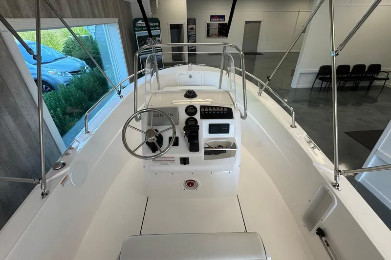 Slide: The Image of 2025 Edgewater 170CC boat interior with steering console and controls in showroom. - 10