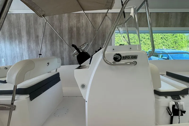Slide: The Image of 2025 Edgewater 170CC boat interior with seating and steering console. - 13