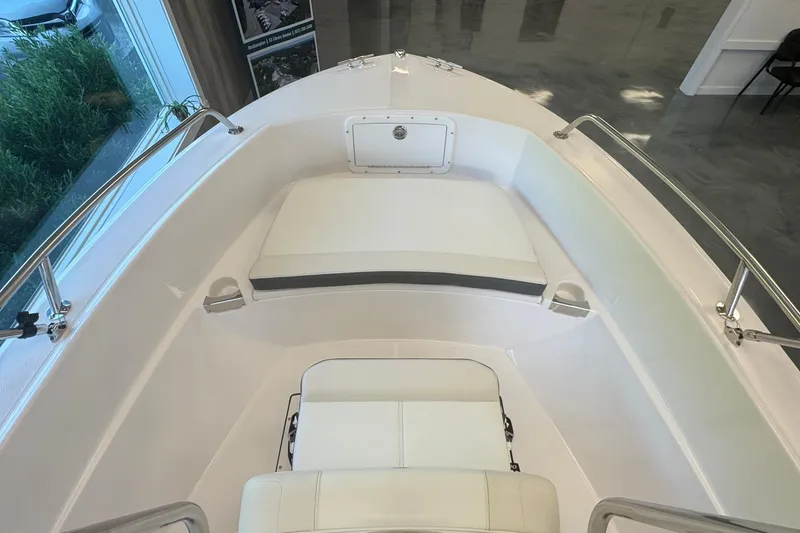 Slide: The Image of 2025 Edgewater 170CC boat interior with white seating and stainless steel railings. - 16