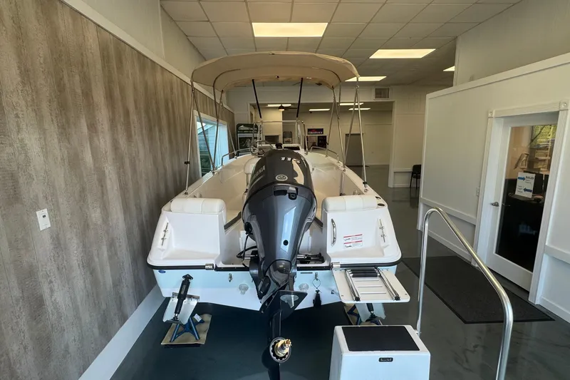 Slide: The Image of 2025 Edgewater 170CC boat displayed indoors with Yamaha outboard motor. - 4