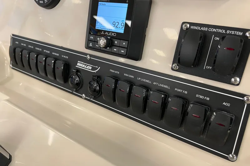 Slide: The Image of Control panel of 2024 Boston Whaler 230 Outrage with switches and JL Audio system. - 19