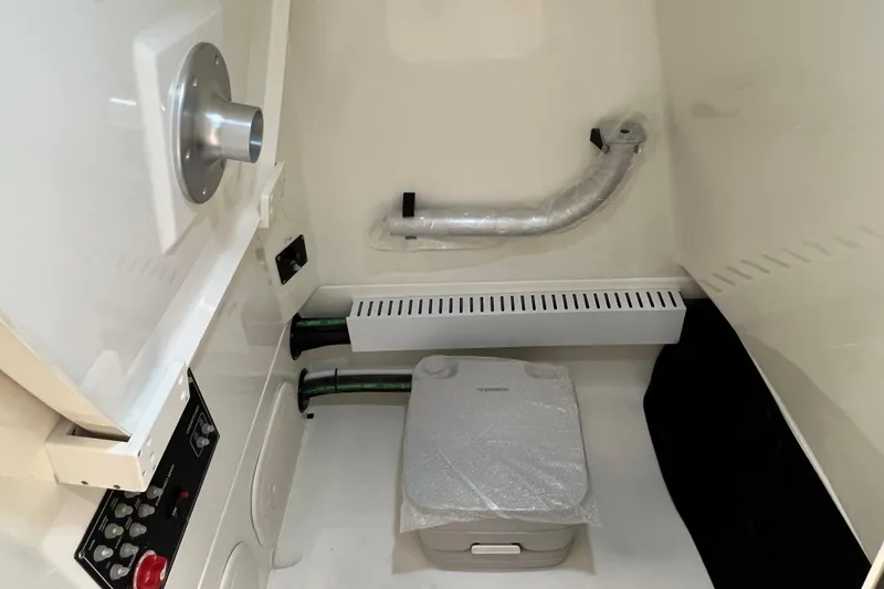 Slide: The Image of 2024 Boston Whaler 230 Outrage interior with control panel and storage compartment. - 27