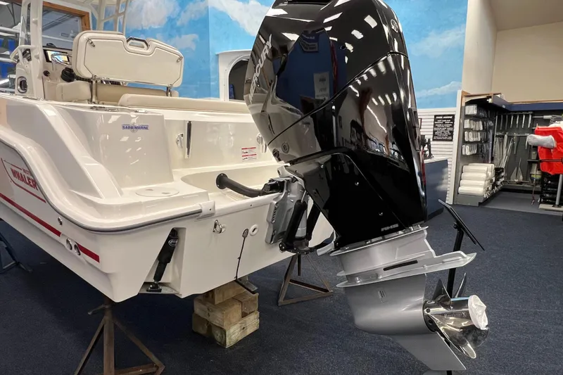 Slide: The Image of 2024 Boston Whaler 230 Outrage boat with powerful outboard motor in showroom. - 3