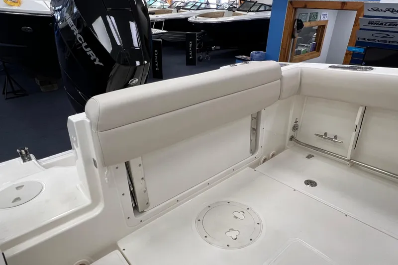 Slide: The Image of 2024 Boston Whaler 230 Outrage boat interior with Mercury engine, showcasing seating and deck features. - 7