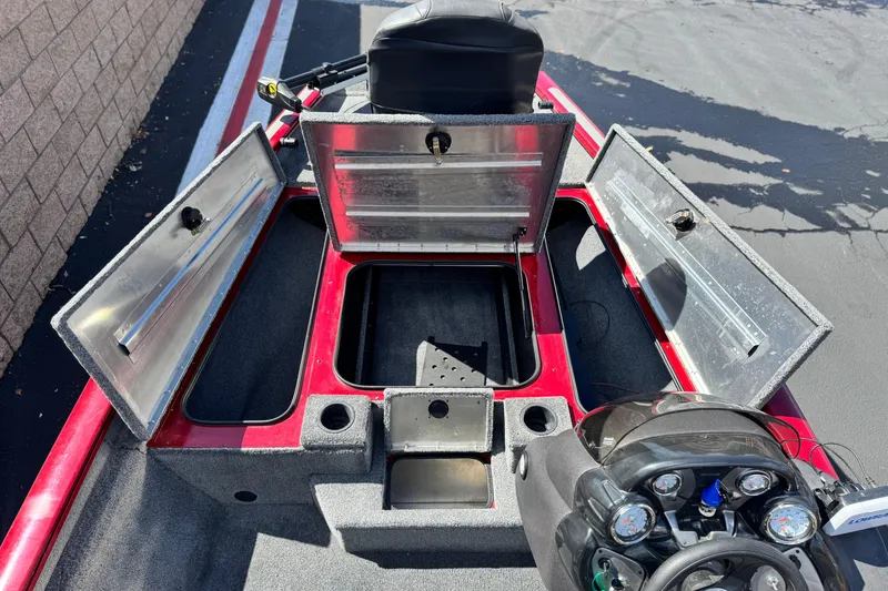 Slide: The Image of 2022 Tracker Pro Team 175 TXW boat interior with open storage compartments and control panel. - 12