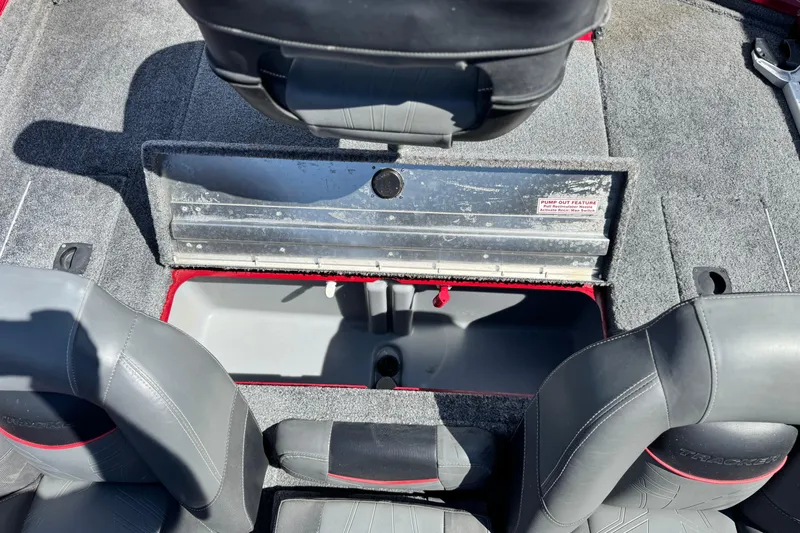 Slide: The Image of 2022 Tracker Pro Team 175 TXW boat interior with open storage compartment and gray seating. - 14