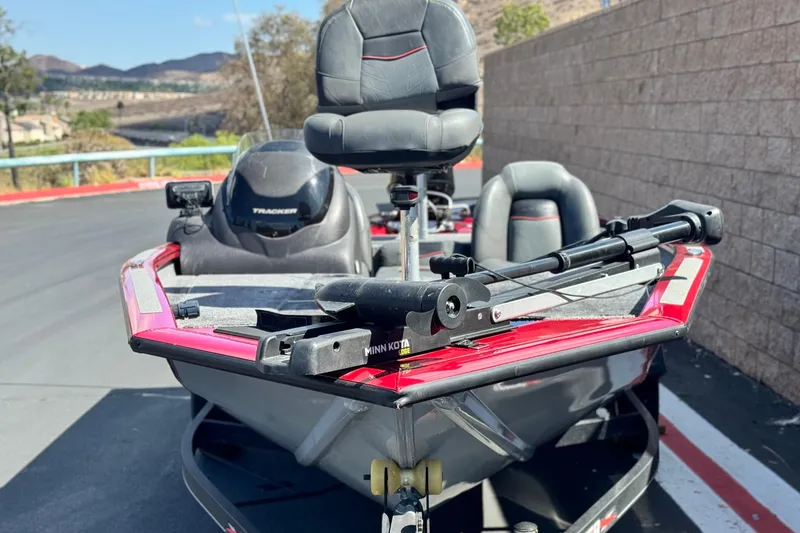 Slide: The Image of 2022 Tracker Pro Team 175 TXW boat with Minn Kota trolling motor, parked outdoors. - 2