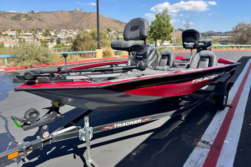 Slide: The Image of 2022 Tracker Pro Team 175 TXW boat on trailer, parked outdoors with scenic background. - 3