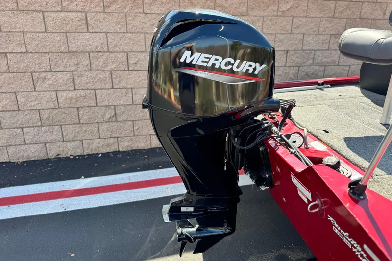 Slide: The Image of 2022 Tracker Pro Team 175 TXW with Mercury outboard motor, parked on pavement. - 6