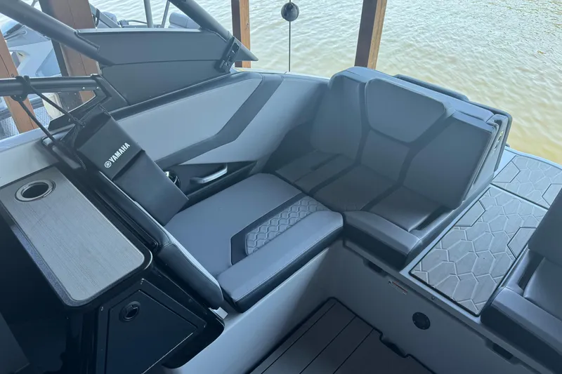 Slide: The Image of 2024 Yamaha Boats 255XE interior seating with modern design and cup holder. - 5
