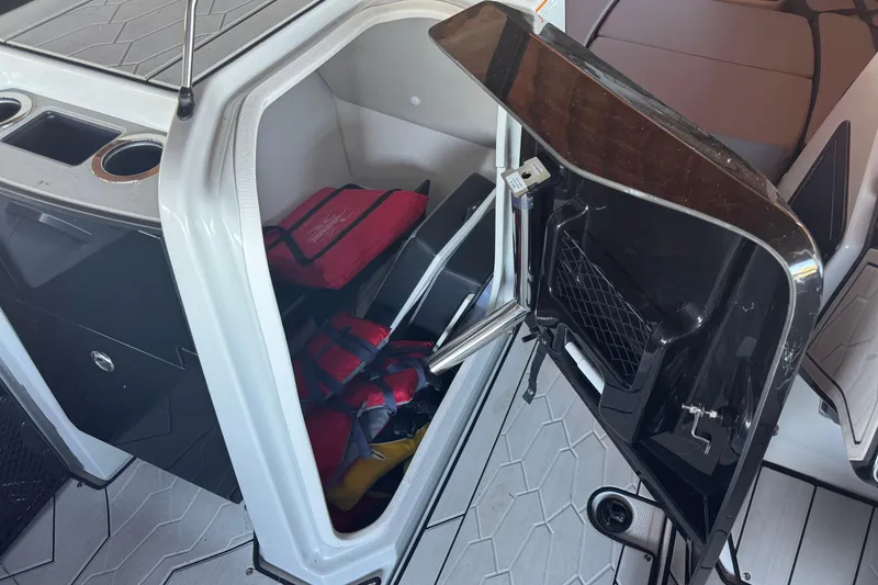 Slide: The Image of 2024 Yamaha Boats 255XE storage compartment with life jackets and accessories. - 9