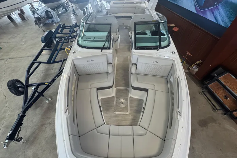 Slide: The Image of 2026 Sea Ray SLX 310 boat interior with spacious seating and modern design in a showroom. - 14