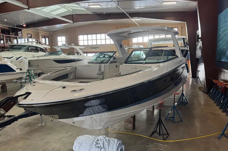 Slide: The Image of 2026 Sea Ray SLX 310 boat displayed in a showroom, showcasing sleek design and luxury features. - 15