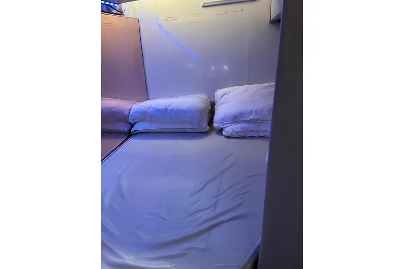 Slide: The Image of Cozy cabin bed in 1987 Californian 44 Veneti yacht, featuring soft pillows and ambient lighting. - 18