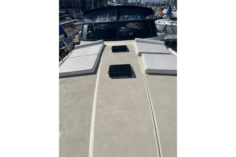 Slide: The Image of 1987 Californian 44 Veneti yacht deck with sun pads and hatches in a marina. - 20