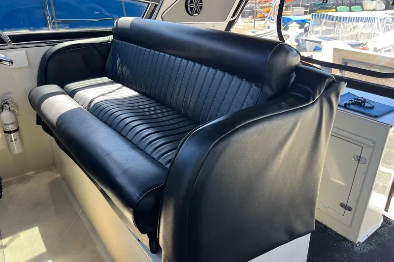 Slide: The Image of Black leather seating on 1987 Californian 44 Veneti boat, with fire extinguisher nearby. - 5
