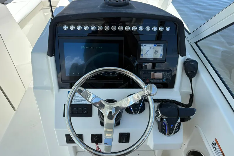 Slide: The Image of Helm of 2026 World Cat 296 DC boat with steering wheel and navigation controls. - 12