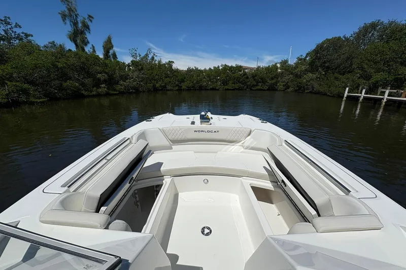 Slide: The Image of 2026 World Cat 296 DC boat interior with seating, surrounded by lush greenery and calm water. - 17