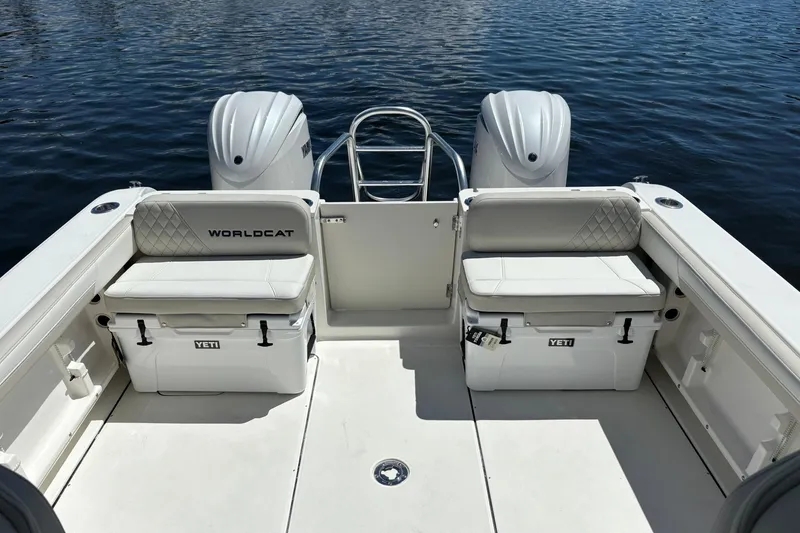 Slide: The Image of 2026 World Cat 296 DC boat interior with Yeti coolers and twin engines on water. - 5