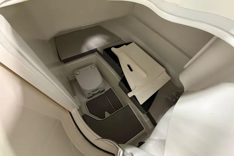 Slide: The Image of 2026 Sea Ray SDX 230 boat interior with compact toilet and storage area. - 18