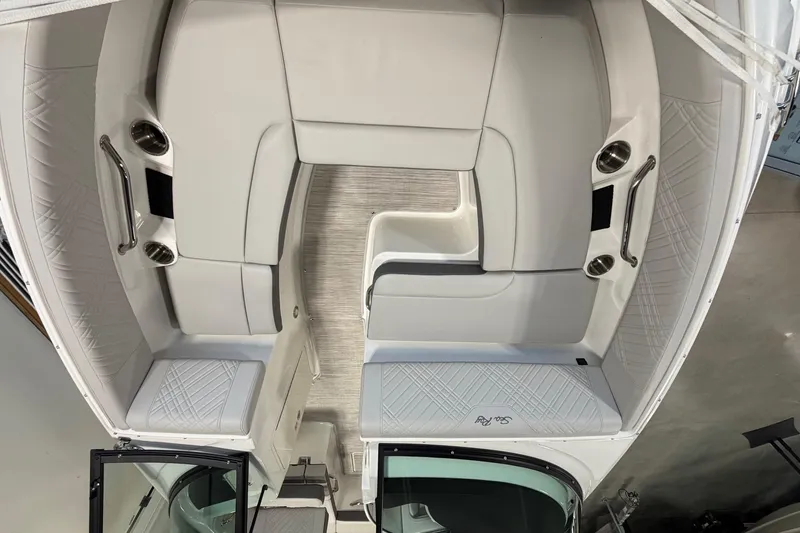 Slide: The Image of 2026 Sea Ray SDX 230 boat interior with white seating and cup holders. - 19