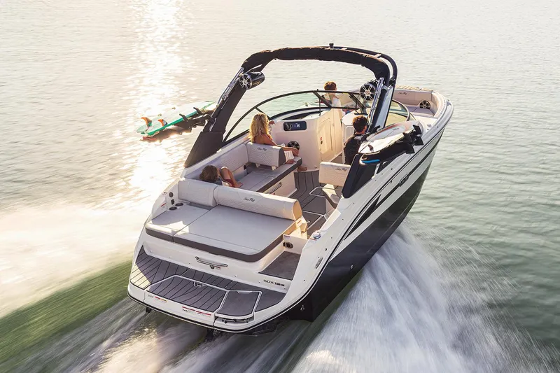 Slide: The Image of 2026 Sea Ray SDX 230 boat on trailer in showroom, black and white design. - 2