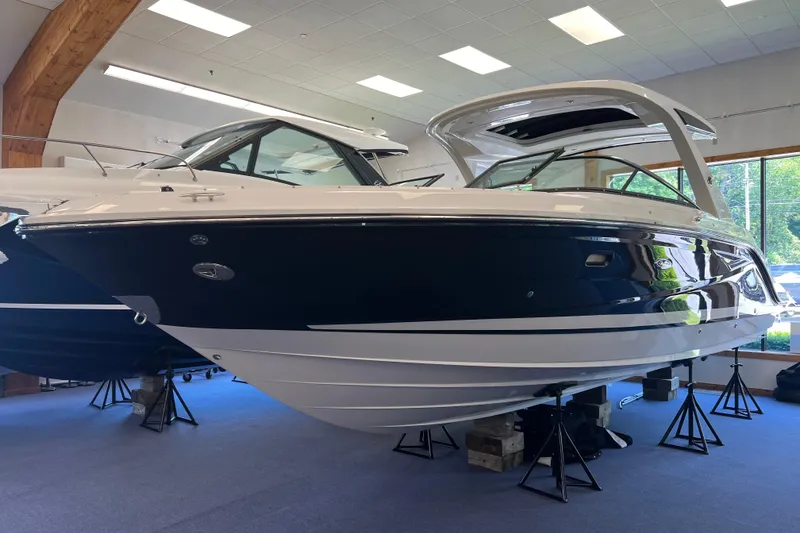 The Image of 2024 Sea Ray SLX 310 boat displayed indoors on stands. - 0