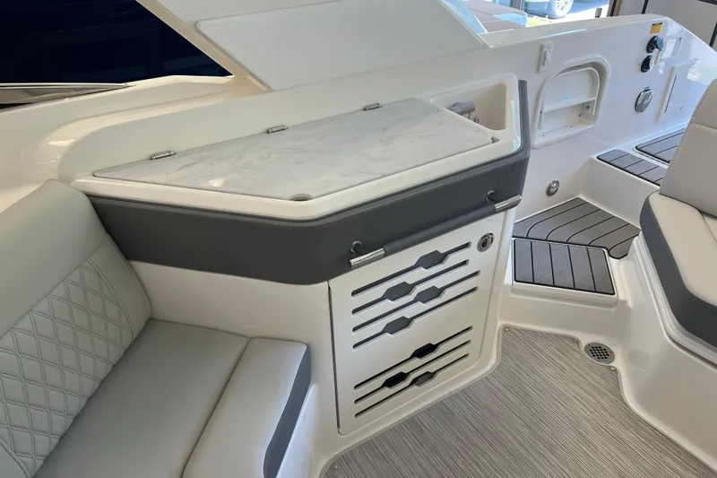 Slide: The Image of 2024 Sea Ray SLX 310 interior with sleek seating and modern storage design. - 11