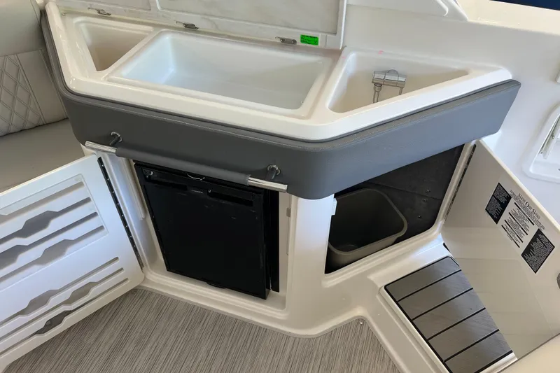 Slide: The Image of 2024 Sea Ray SLX 310 boat interior with sink, storage, and refrigerator. - 12
