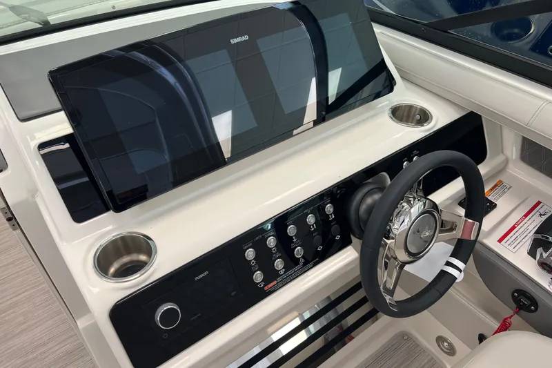 Slide: The Image of 2024 Sea Ray SLX 310 helm with Simrad display and modern steering wheel. - 17
