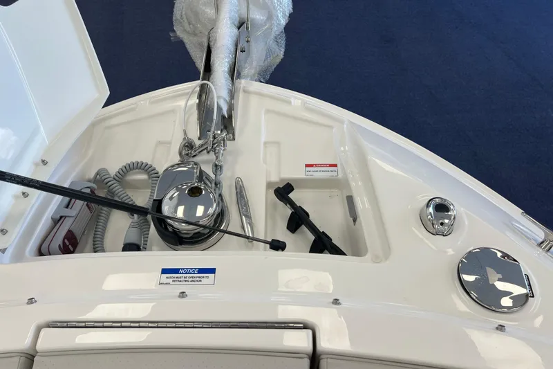 Slide: The Image of 2024 Sea Ray SLX 310 boat anchor compartment with equipment and safety notices. - 25