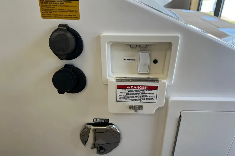 Slide: The Image of 2024 Sea Ray SLX 310 boat control panel with platform switch and warning labels. - 7