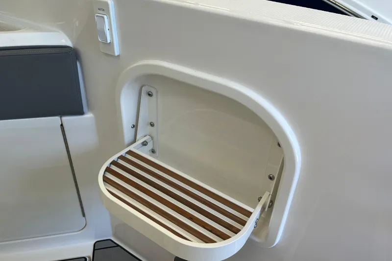 Slide: The Image of 2024 Sea Ray SLX 310 boat hatch with wooden slatted step detail. - 8