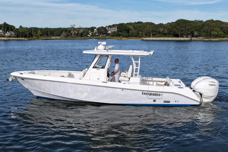 Slide: The Image of 2020 Everglades 335 Center Console boat cruising on a serene lake. - 12