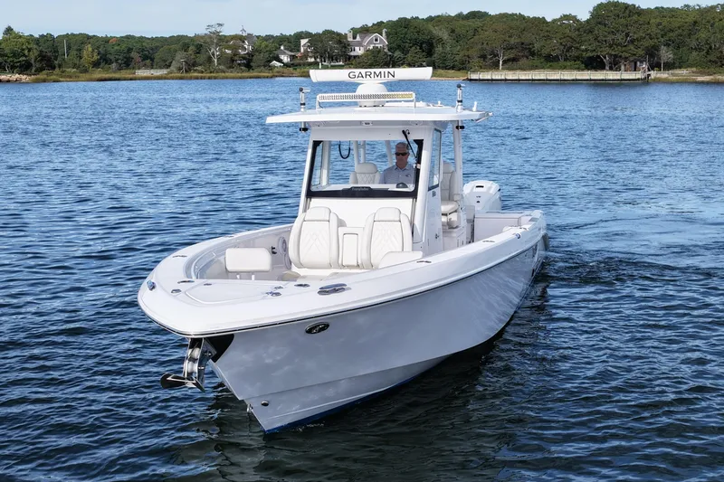 Slide: The Image of 2020 Everglades 335 Center Console boat cruising on a serene lake. - 2