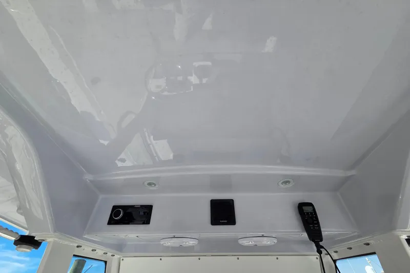 Slide: The Image of 2020 Everglades 335 Center Console boat interior with electronic controls and communication devices. - 23