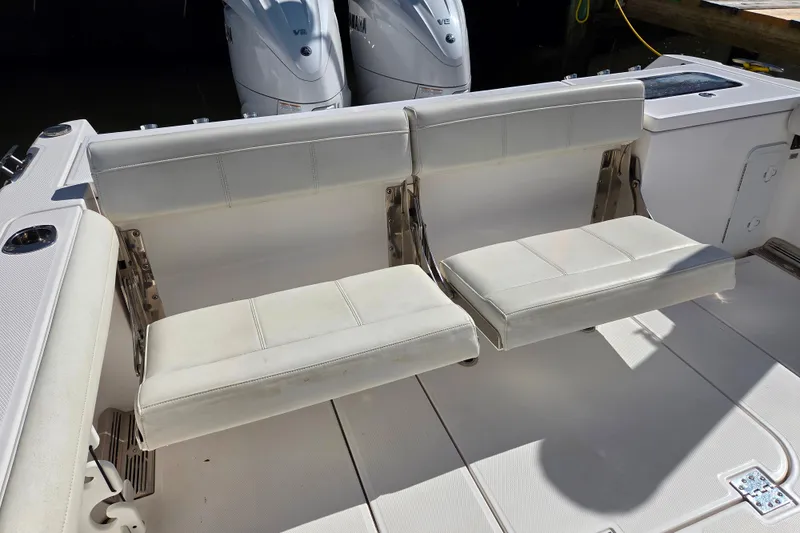 Slide: The Image of 2020 Everglades 335 Center Console boat with white foldable seats and dual engines. - 25