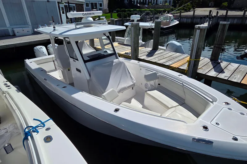 Slide: The Image of 2020 Everglades 335 Center Console boat docked, featuring sleek design and spacious seating. - 26