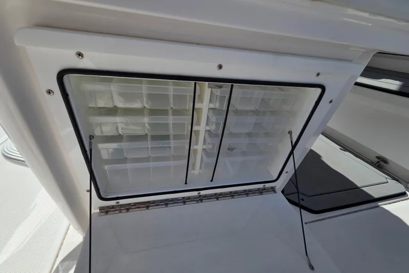 Slide: The Image of Storage compartment on 2020 Everglades 335 Center Console boat, featuring organized shelves. - 33