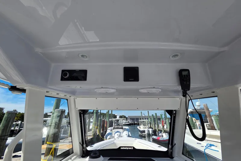 Slide: The Image of 2020 Everglades 335 Center Console boat interior with control panel and dock view. - 36